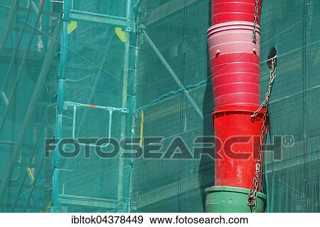 Construction site, downpipe for rubble, façade of building covered in green tarpaulin, city centre, Lübeck, Germany, Europe View Large Photo Image Stock Photo - Construction site, downpipe for rubble, façade of building covered in green tarpaulin, city centre, Lübeck, Germany, Europe. Fotosearch
