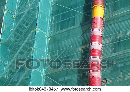 Construction site, downpipe for rubble, façade of building covered in green tarpaulin, city centre, Lübeck, Germany, Europe View Large Photo Image Stock Photo - Construction site, downpipe for rubble, façade of building covered in green tarpaulin, city centre, Lübeck, Germany, Europe. Fotosearch