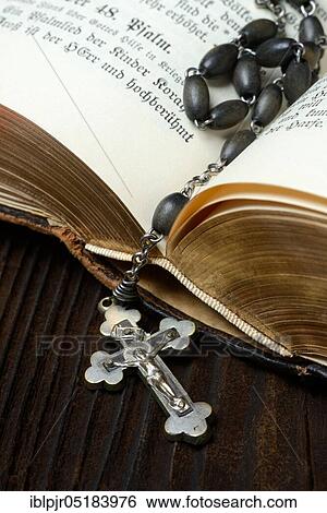 Stock Photograph - Crucifix and rosary chain on bible, rosary chain. Fotosearch