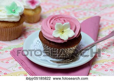 Stock Image - Cupcake on plate with cake fork. Fotosearch