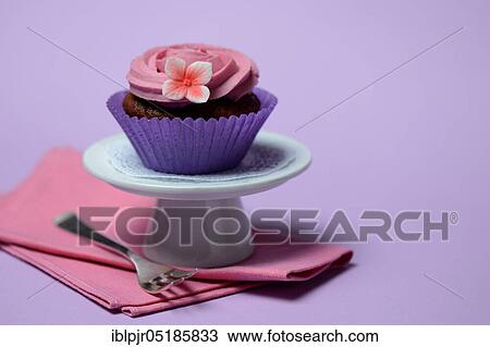 Stock Image - Cupcake on plate with cake fork. Fotosearch