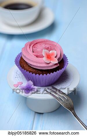 Stock Photograph - Cupcake on plate with cake fork. Fotosearch