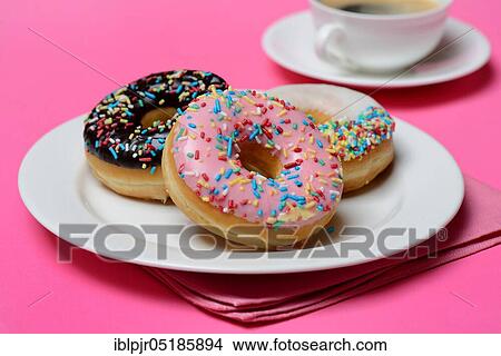 Donuts on plate and cup of coffee, candy, icing, sugar icing View Large Photo Image Picture - Donuts on plate and cup of coffee, candy, icing, sugar icing. Fotosearch
