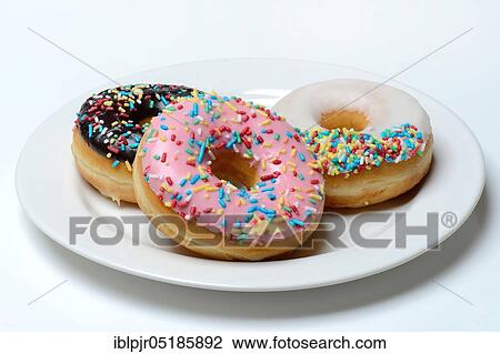 Stock Image - Donuts on plate, sugar icing, sugar glaze. Fotosearch