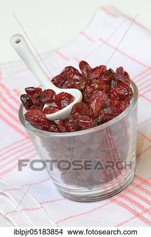 Picture - Dried cranberriesin glass with spoon (Vaccinium macrocarpon). Fotosearch
