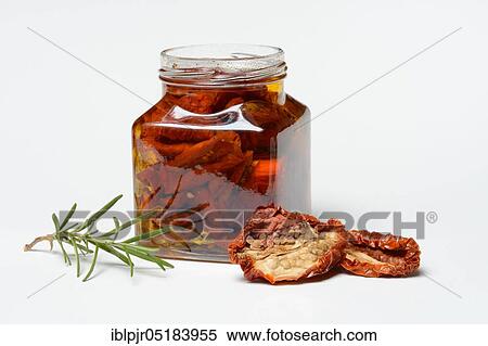 Stock Photography - Dried tomatoes in jar with olive oil, antipasti, olive oil. Fotosearch