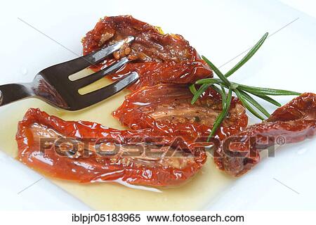 Stock Photography - Dried tomatoes in jar with olive oil, antipasti, olive oil. Fotosearch