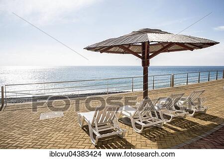 Picture - Empty beach promenade, deckchairs, Ponta do Garajau, Santa Cruz, Madeira, Portugal, Europe. Fotosearch