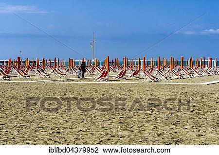 Empty orange deckchairs and sunshades on beach, early season, Viareggio, Tuscany, Italy, Europe View Large Photo Image Stock Image - Empty orange deckchairs and sunshades on beach, early season, Viareggio, Tuscany, Italy, Europe. Fotosearch