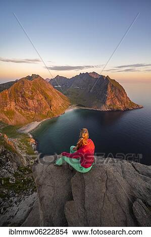 Evening atmosphere, hiker on top of Ryten, sea, Kvalvika beach and mountains, Fredvang, Lofoten, Nordland, Norway, Europe View Large Photo Image Picture - Evening atmosphere, hiker on top of Ryten, sea, Kvalvika beach and mountains, Fredvang, Lofoten, Nordland, Norway, Europe. Fotosearch