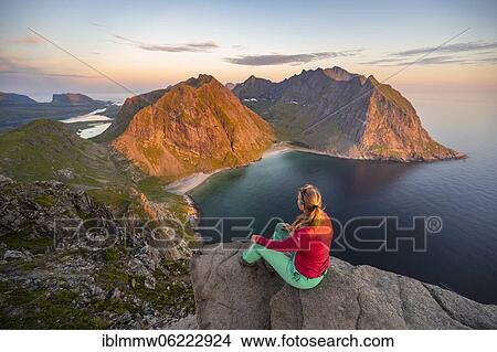 Evening atmosphere, hiker on top of Ryten, sea, Kvalvika beach and mountains, Fredvang, Lofoten, Nordland, Norway, Europe View Large Photo Image Picture - Evening atmosphere, hiker on top of Ryten, sea, Kvalvika beach and mountains, Fredvang, Lofoten, Nordland, Norway, Europe. Fotosearch