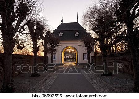 Stock Photograph - Gatehouse with tree avenue in the morning, Knechtsteden Monastery, Dormagen, Lower Rhine, North Rhine-Westphalia, Germany, Europe. Fotosearch