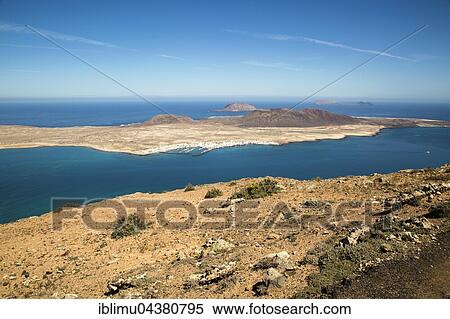 Graciosa Island and El Rio channel, Chinijo archipelago, Lanzarote, Canary Islands, Spain, Europe View Large Photo Image Stock Photography - Graciosa Island and El Rio channel, Chinijo archipelago, Lanzarote, Canary Islands, Spain, Europe. Fotosearch