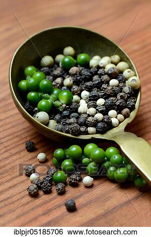 Stock Photograph - Green, black and white pepper in brass ladle, pepper syrup, pepper panicles, peppercorns. Fotosearch