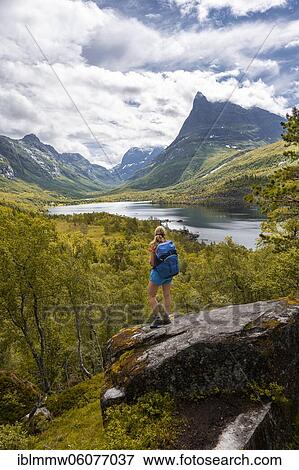 Stock Photo - Hiker on rocks, high valley Innerdalen with lake Innerdalsvatna, mountains, right Innerdalstårnet, Trollheimen Mountain Area, Sunndal, Møre og Romsdal, Vestlandet, Norway, Europe. Fotosearch