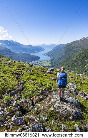 Stock Image - Hiker on the trail to Skåla mountain, Innvikfjorden fjord, Jostedalsbreen National Park, Stryn, Vestland, Norway, Europe. Fotosearch