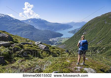 Stock Image - Hiker on the trail to Skåla mountain, Innvikfjorden fjord, Jostedalsbreen National Park, Stryn, Vestland, Norway, Europe. Fotosearch