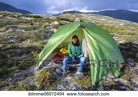 Picture - Hiker sitting in a tent, tundra, barren landscape, Dovrefjell National Park, Oppdal, Norway, Europe. Fotosearch