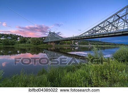 Stock Image - Historical bridge Blaues Wunder is crossing the river Elbe at dust with red cloud above it, Dresden, Saxony, Germany, Europe. Fotosearch