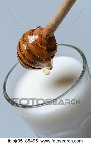 Stock Photography - Honey milk, glass of milk with honey, honey spoon. Fotosearch