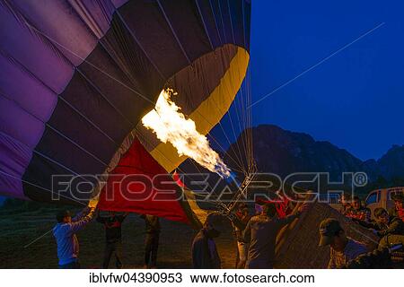 Hot air balloon being inflated with fire, takeoff preparations on ground, dawn, Vang Vieng, Vientiane Province, Laos, Asia View Large Photo Image Stock Image - Hot air balloon being inflated with fire, takeoff preparations on ground, dawn, Vang Vieng, Vientiane Province, Laos, Asia. Fotosearch