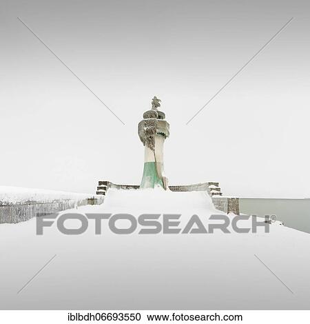 Stock Image - Iced quay wall and lighthouse in the harbour of Sassnitz on the island of Rügen, Mecklenburg-Western Pomerania, Germany, Europe. Fotosearch