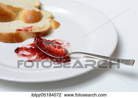 Stock Image - Jam and slice of braided butter, raspberry jam. Fotosearch
