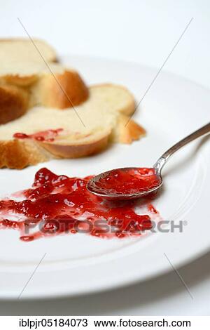 Stock Image - Jam and slice of braided butter, raspberry jam. Fotosearch