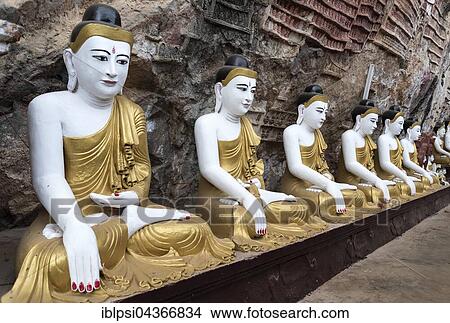 Picture - Line of Buddha statues at Kaw-goon Cave Temple, Mon State, Myanmar, Asia. Fotosearch