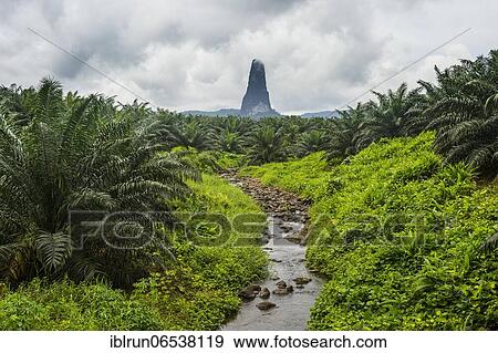 Stock Photo - Little creek leading to the unusal monolith, Pico Cao Grande, east coast of Sao Tome, Sao Tome and Principe, Atlantic Ocean, Africa. Fotosearch