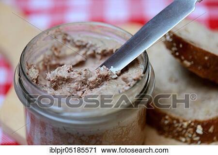 Stock Image - Liver sausage in glass with knife, homemade liver sausage. Fotosearch
