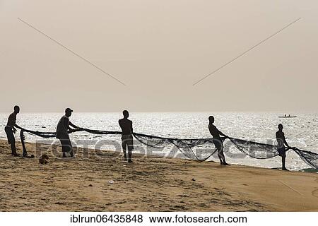 Local fishermen pulling their nets on a beach in Robertsport, Liberia, Africa View Large Photo Image Stock Photo - Local fishermen pulling their nets on a beach in Robertsport, Liberia, Africa. Fotosearch