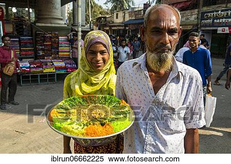 Stock Photography - Man holding a colourful plate of food, Dhaka, Bangladesh, Asia. Fotosearch