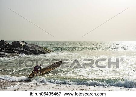 Man mounts his dugout canoe on the ocean east of Buchanan, Liberia, Africa View Large Photo Image Stock Photo - Man mounts his dugout canoe on the ocean east of Buchanan, Liberia, Africa. Fotosearch