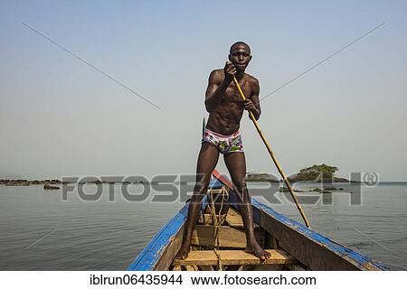 Man pushing his small boat on Banana islands, Sierra Leone, Africa View Large Photo Image Picture - Man pushing his small boat on Banana islands, Sierra Leone, Africa. Fotosearch