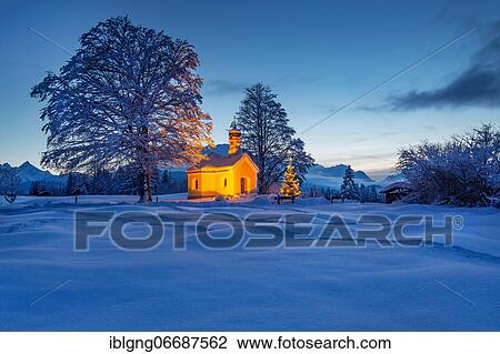 Stock Image - Maria Rast chapel on the hunchback meadows with Christmas tree and Wetterstein mountains at dusk, Krün, Werdenfelser Land, Upper Bavaria, Bavaria, Germany, Europe. Fotosearch