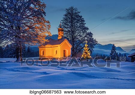 Stock Image - Maria Rast chapel on the hunchback meadows with Christmas tree and Wetterstein mountains at dusk, Krün, Werdenfelser Land, Upper Bavaria, Bavaria, Germany, Europe. Fotosearch