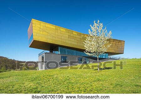 Stock Photo - Nebra Ark in spring, flowering cherry tree, meadow with dandelion, Museum of the Sky Disk, Visitor Center, Nebra, Burgenlandkreis, Saxony-Anhalt, Germany, Europe. Fotosearch