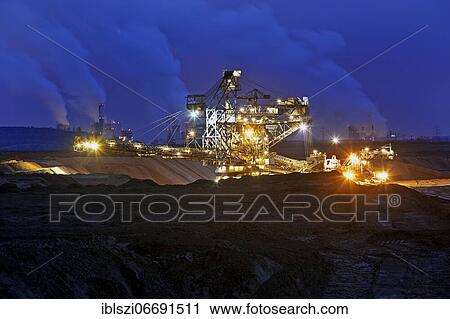 Opencast lignite mine with stacker and power plants in the evening, Garzweiler, Jüchen, Rhenish lignite mining area, North Rhine-Westphalia, Germany, Europe View Large Photo Image Stock Image - Opencast lignite mine with stacker and power plants in the evening, Garzweiler, Jüchen, Rhenish lignite mining area, North Rhine-Westphalia, Germany, Europe. Fotosearch