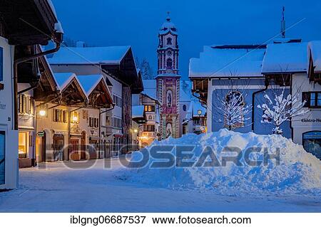 Stock Photo - Pedestrian zone in the center with typical houses and parish church at dusk, Mittenwald, Werdenfelser Land, Upper Bavaria, Bavaria, Germany, Europe. Fotosearch