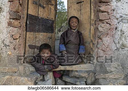 Picture - Portrait, children in front of a wooden door, Saldang, Dolpo, Nepal, Asia. Fotosearch