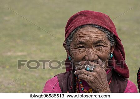 Stock Image - Portrait of an elderly woman with turquoise earring and finger ring, Dolpo, Nepal, Asia. Fotosearch