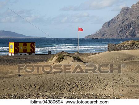 Red flag flying warning of bathing danger, La Caleta de Famara, Lanzarote, Canary islands, Spain, Europe View Large Photo Image Picture - Red flag flying warning of bathing danger, La Caleta de Famara, Lanzarote, Canary islands, Spain, Europe. Fotosearch