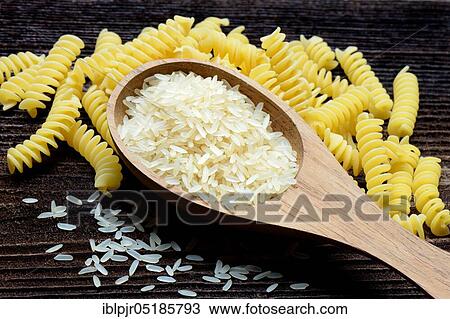 Rice grains in wooden spoon and spiral noodles, rice grain, rice grains, fusilli, uncooked View Large Photo Image Stock Image - Rice grains in wooden spoon and spiral noodles, rice grain, rice grains, fusilli, uncooked. Fotosearch