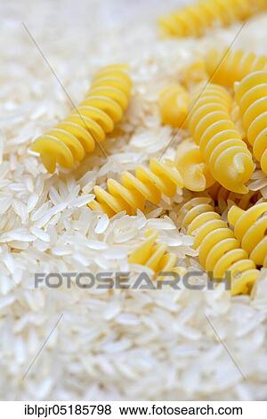 Rice grains in wooden spoon and spiral noodles, rice grain, rice grains, fusilli, uncooked View Large Photo Image Stock Photo - Rice grains in wooden spoon and spiral noodles, rice grain, rice grains, fusilli, uncooked. Fotosearch