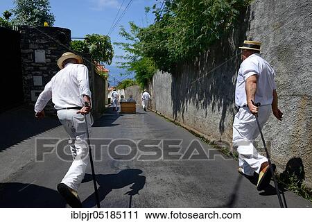 Stock Image - Ride with the basket sledge, men pull and push basket sledge, Monte, Funchal, Madeira, Portugal, Europe. Fotosearch