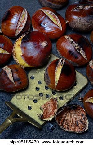 Stock Image - Roasted chestnuts ( Castanea sativa) with trowel. Fotosearch
