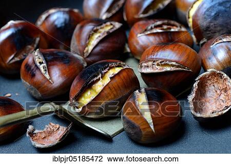 Stock Image - Roasted chestnuts ( Castanea sativa) with trowel. Fotosearch