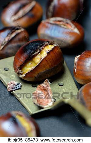 Stock Image - Roasted chestnuts ( Castanea sativa) with trowel. Fotosearch