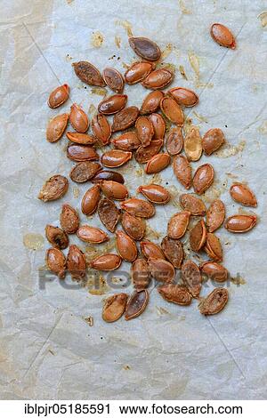 Stock Image - Roasted pumpkin seeds with skin. Fotosearch